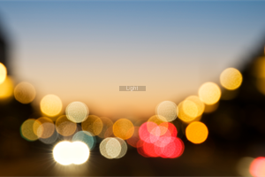 città di notte con luci sfuocate col tramonto in lontananza.